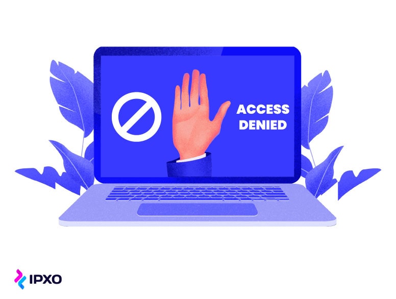 A hand on a laptop screen with the access denied warning message.