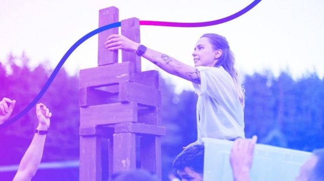 A photo of a person building an oversized jenga tower.